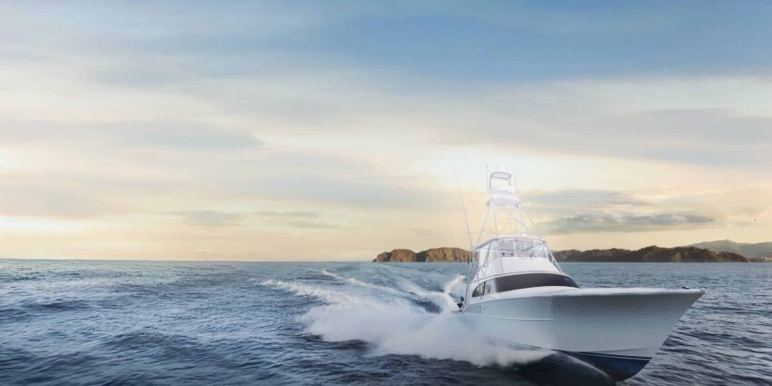 A white fishing boat travels at a high speed in open waters in the early morning.